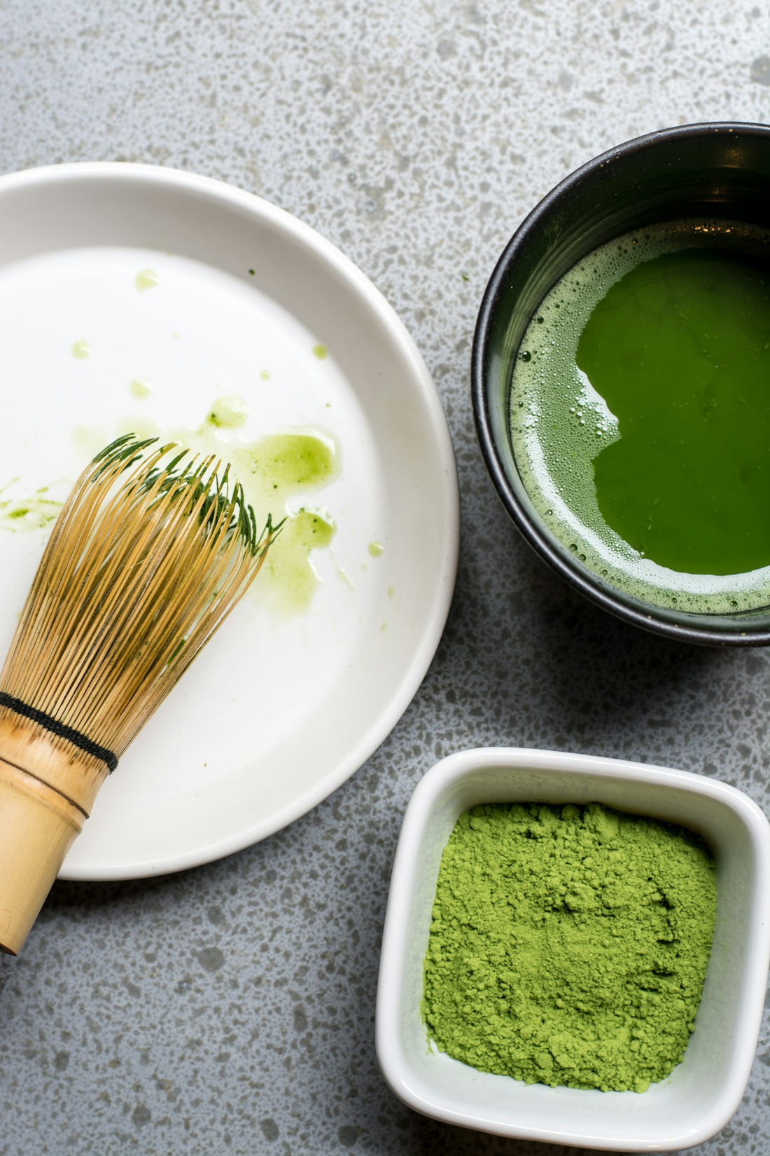 Grünes Matcha-Pulver in einer weissen Keramikschale, bereit zum Aufschlagen
