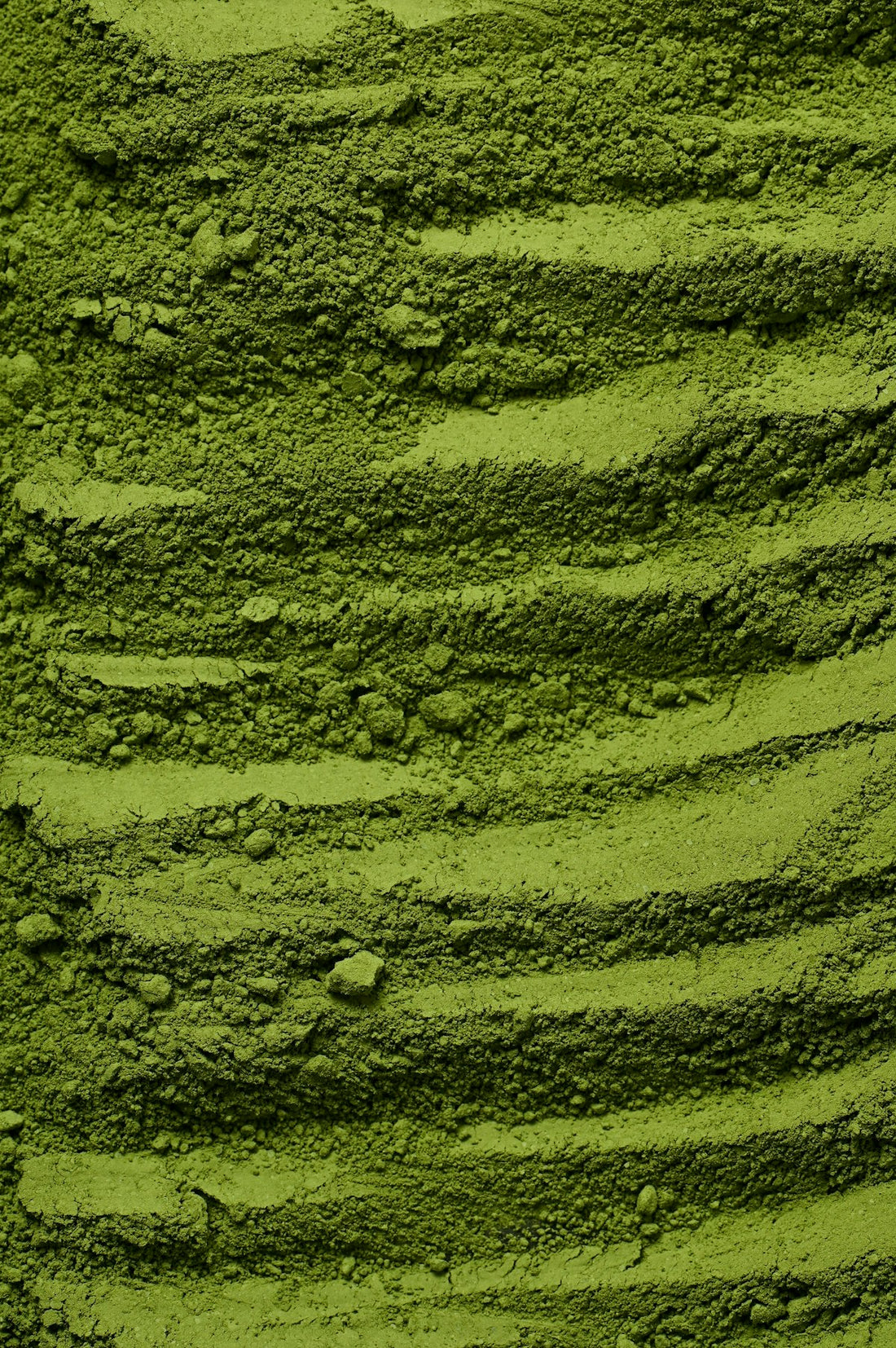 Leuchtend grünes Matcha-Pulver in einer Schale, die intensive Farbe zeigt optimale Frische und Qualität