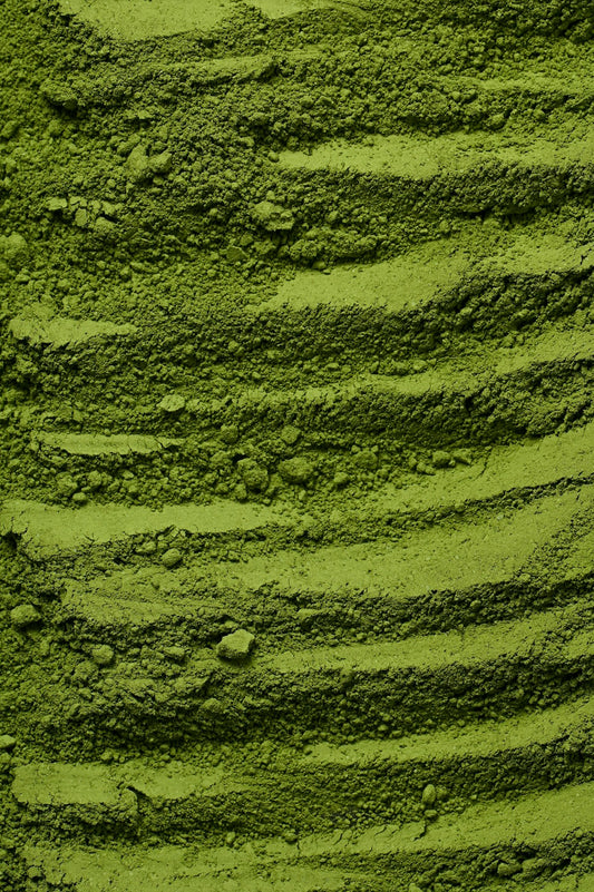 Leuchtend grünes Matcha-Pulver in einer Schale, die intensive Farbe zeigt optimale Frische und Qualität