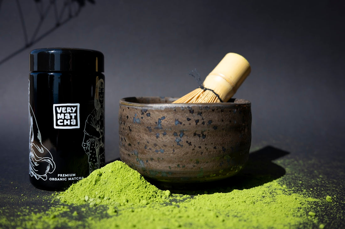 Matcha-Pulver mit Bambusbesen und Behälter bereit zur Zubereitung
